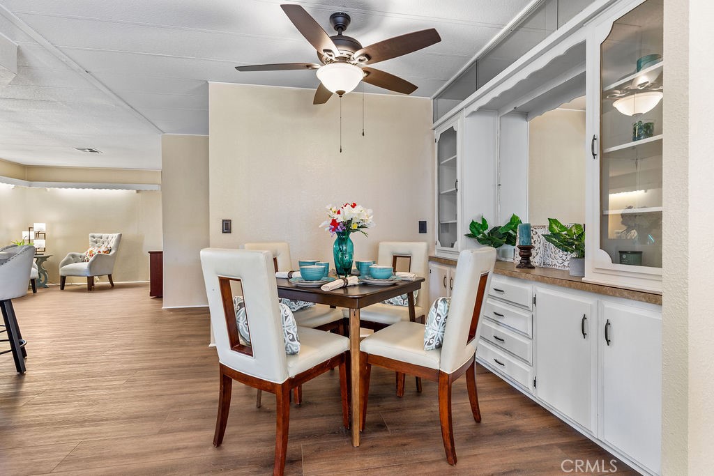 13393 Mariposa Road, Unit 99 Victorville, CA 92395 - Photo 14 of 50 a dining room with furniture potted plants and wooden floor