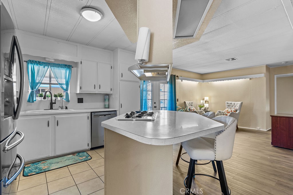 13393 Mariposa Road, Unit 99 Victorville, CA 92395 - Photo 17 of 50 a kitchen with a table chairs sink and cabinets