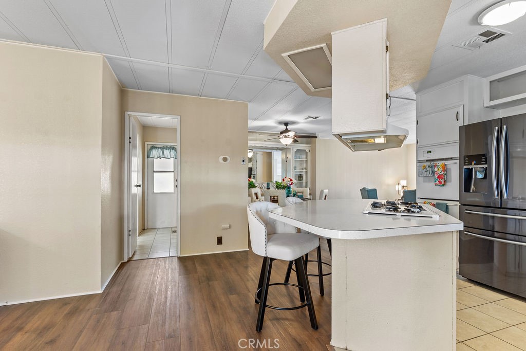 13393 Mariposa Road, Unit 99 Victorville, CA 92395 - Photo 25 of 50 a kitchen with stainless steel appliances a dining table chairs sink and stove