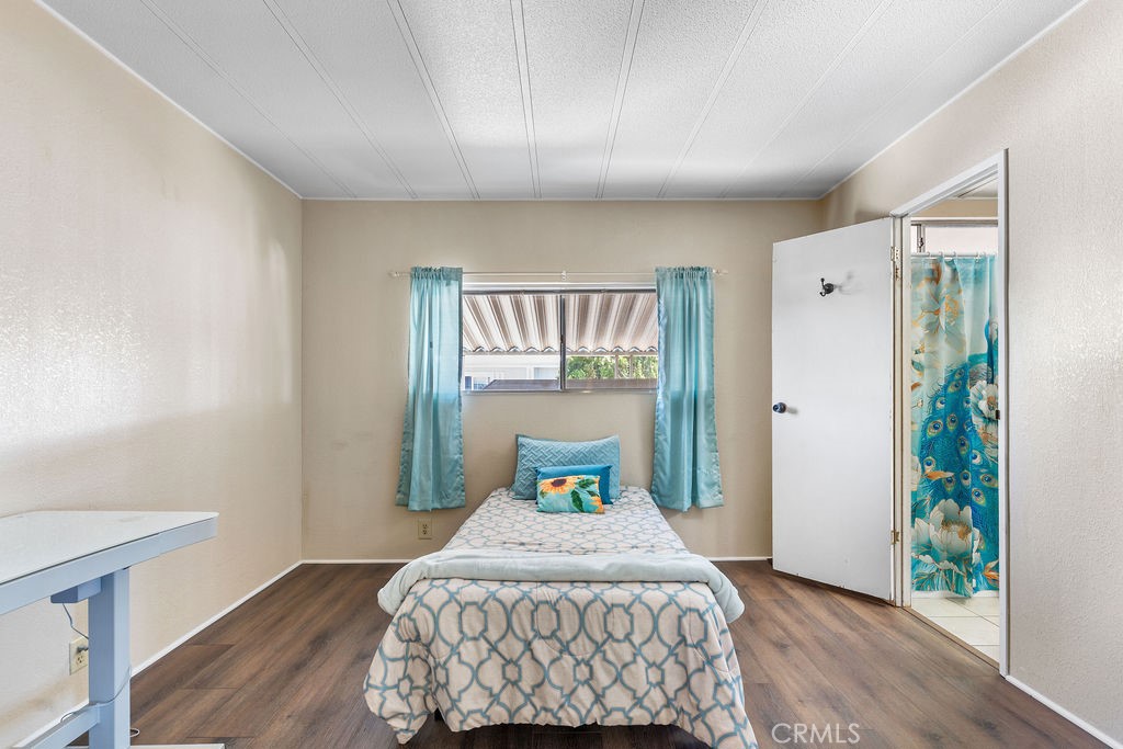 13393 Mariposa Road, Unit 99 Victorville, CA 92395 - Photo 27 of 50 a bedroom with a bed and wooden floor