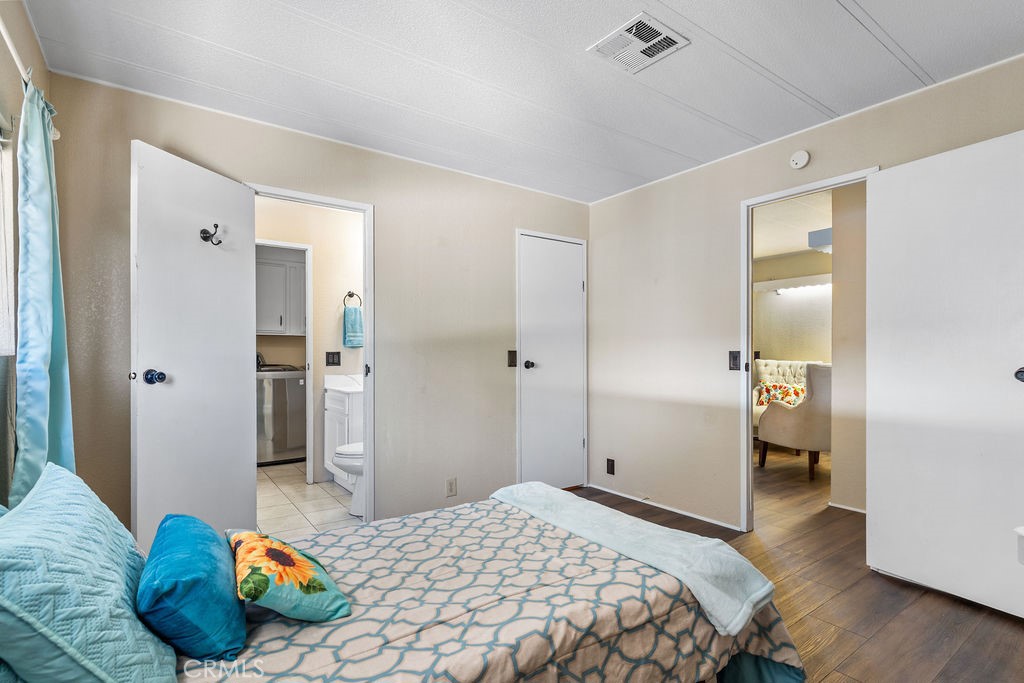 13393 Mariposa Road, Unit 99 Victorville, CA 92395 - Photo 28 of 50 a bedroom with a bed and wooden floor