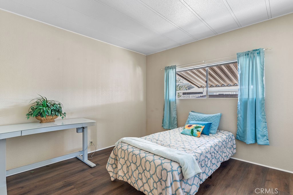 13393 Mariposa Road, Unit 99 Victorville, CA 92395 - Photo 29 of 50 a bedroom with a bed and a potted plant