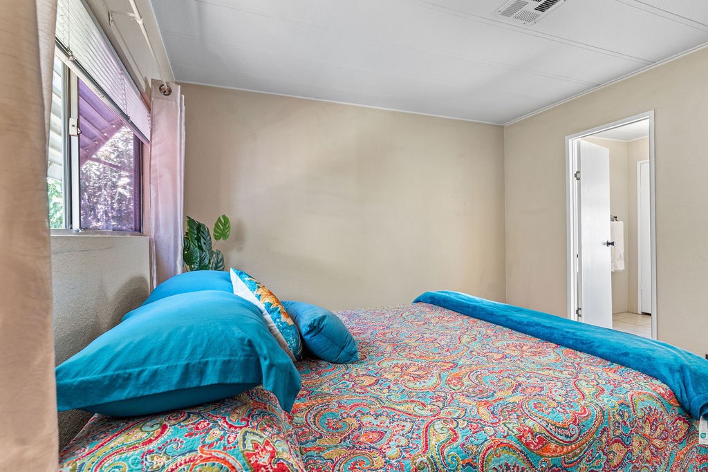 13393 Mariposa Road, Unit 99 Victorville, CA 92395 - Photo 35 of 50 a bedroom with a bed and a painting on the wall