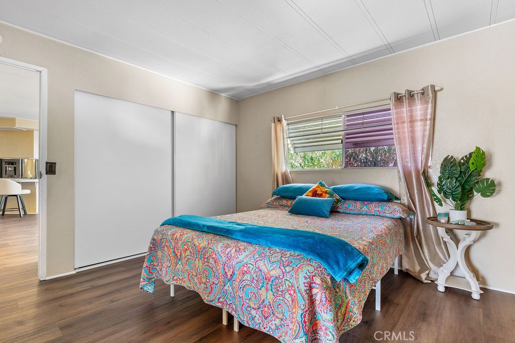 13393 Mariposa Road, Unit 99 Victorville, CA 92395 - Photo 36 of 50 a bedroom with a bed and wooden floor