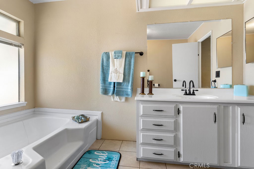 13393 Mariposa Road, Unit 99 Victorville, CA 92395 - Photo 39 of 50 a bathroom with a tub a sink and a mirror