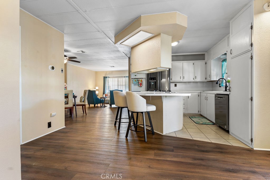 13393 Mariposa Road, Unit 99 Victorville, CA 92395 - Photo 43 of 50 a kitchen with stainless steel appliances a dining table chairs microwave and view living room