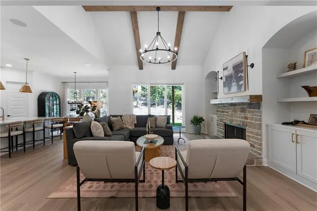a living room with furniture a fireplace and a large window
