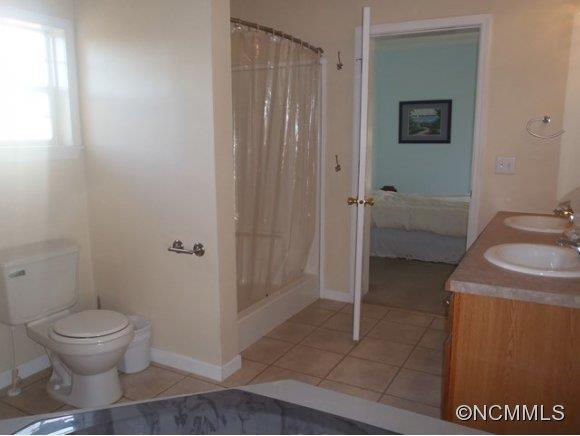 1585 Gilmer Edwards Road Rutherfordton, NC 28139 - Photo 16 of 23 a bathroom with a granite countertop sink a toilet and shower