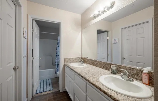 a bathroom with a granite countertop sink a toilet and a mirror