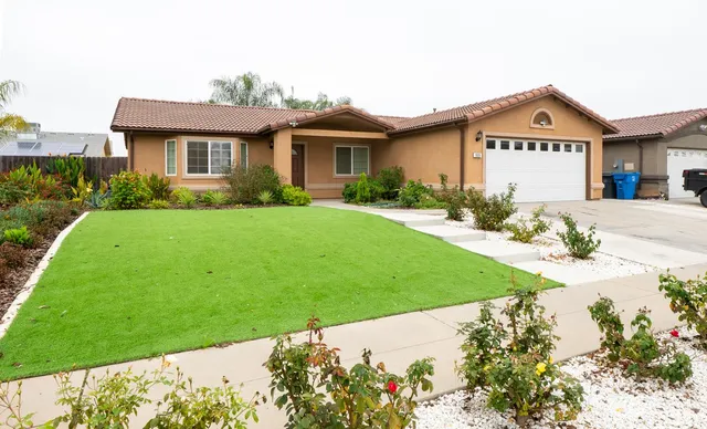 a front view of a house with a garden and yard