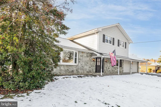 a view of a white house with a large tree in front of it