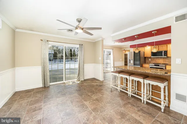 a kitchen with stainless steel appliances granite countertop a stove top oven a sink and a refrigerator
