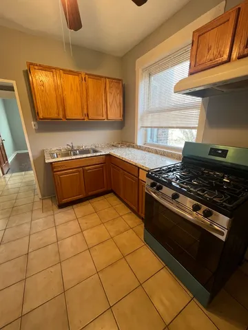a kitchen with granite countertop a stove a sink and a microwave