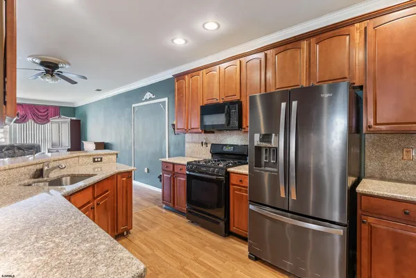 a kitchen with a refrigerator sink and wooden cabinets