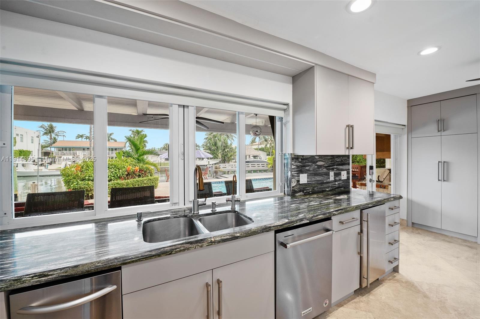 2015 Northeast 120th Road North Miami, FL 33181 - Photo 20 of 67 a kitchen with stainless steel appliances granite countertop a sink a stove and cabinets