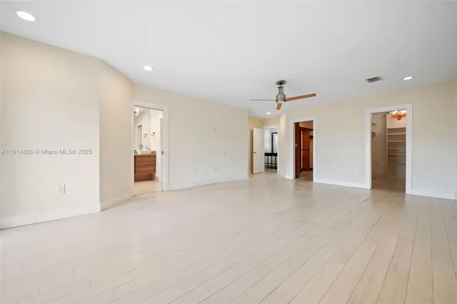 a view of an empty room with a cabinet and a window