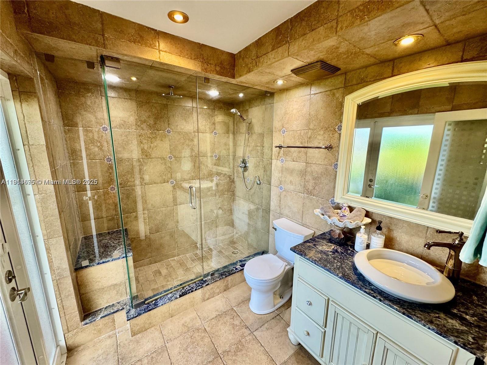 2015 Northeast 120th Road North Miami, FL 33181 - Photo 65 of 67 a bathroom with a granite countertop sink a toilet a mirror and shower
