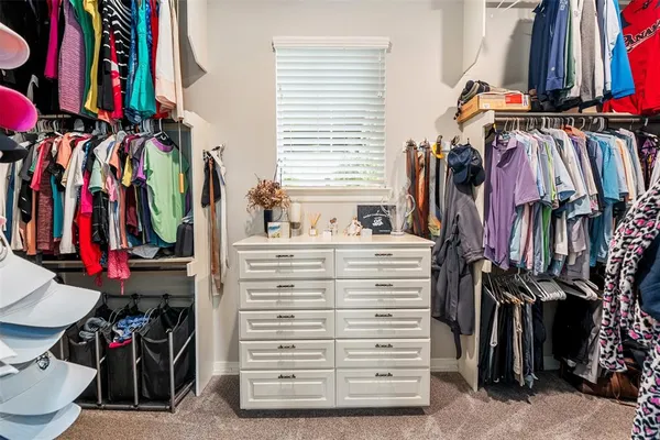 a view of walk in closet with clothes