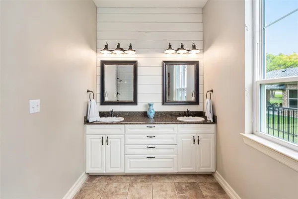 a bathroom with a double vanity sink and a mirror
