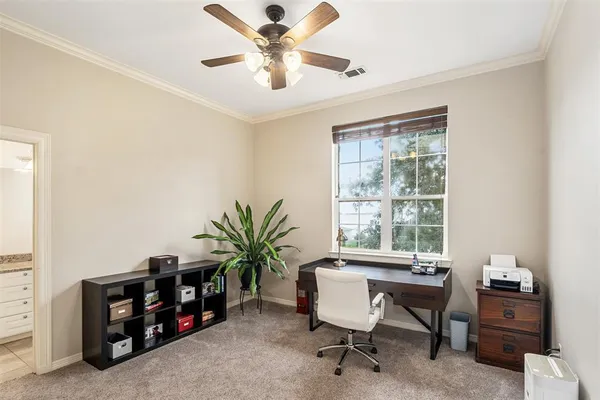 a view of a workspace with furniture and a window