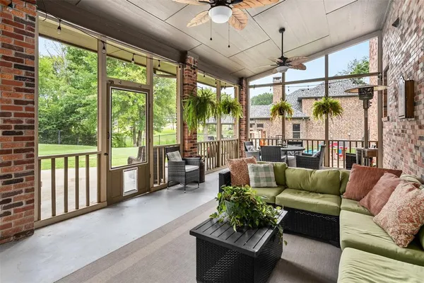 a living room with furniture and a large window with garden view