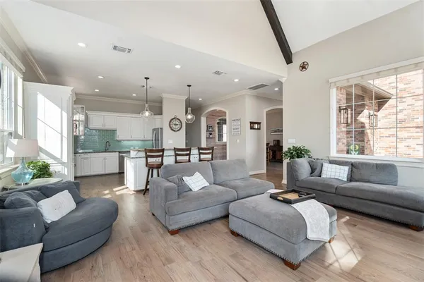 a living room with furniture kitchen and a large window