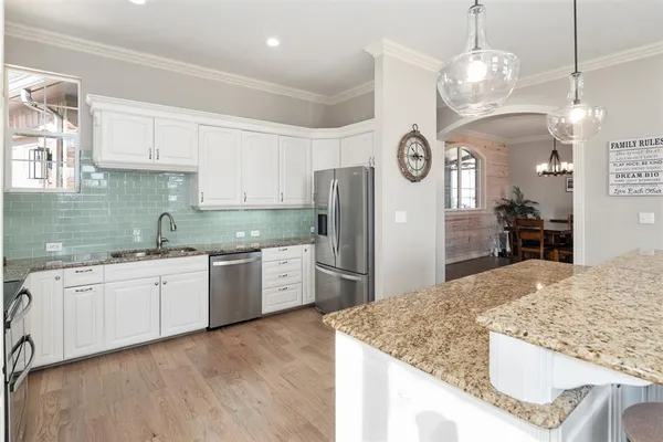 a large kitchen with stainless steel appliances granite countertop a sink dishwasher a refrigerator and a stove