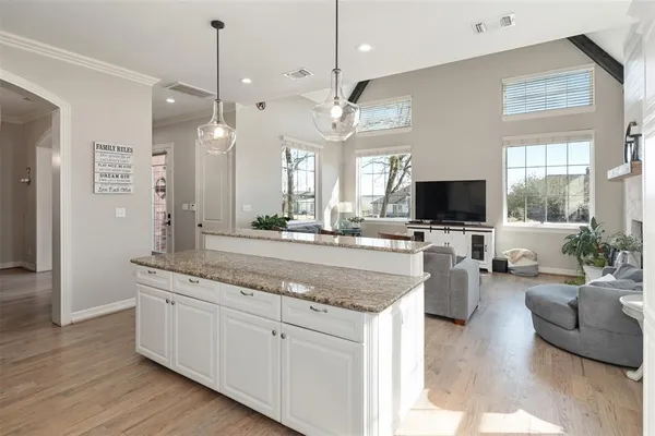 a living room with granite countertop couches a flat screen tv and kitchen view