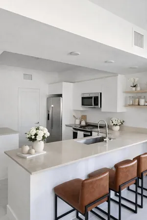 a kitchen with stainless steel appliances a dining table and chairs