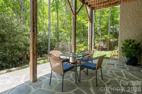 a view of a patio with table and chairs and floor to ceiling window