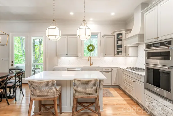 a kitchen with a table chairs stove and cabinets