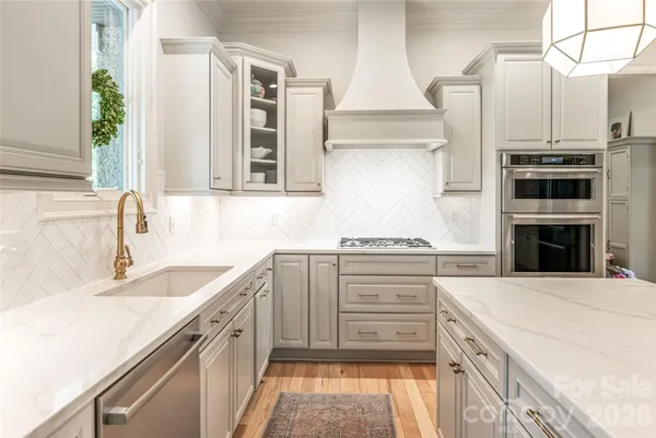 a kitchen with granite countertop a sink stainless steel appliances and cabinets