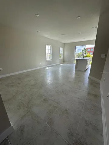 a view of a kitchen with refrigerator and white cabinets