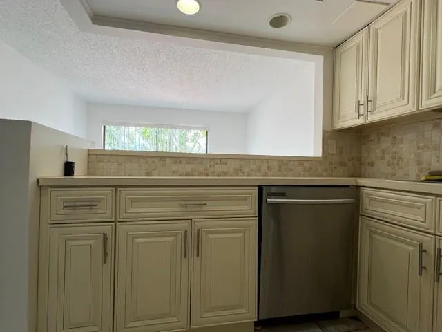a view of a kitchen with white cabinets and a refrigerator