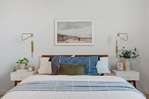 a bedroom with a bed lamp and a chandelier