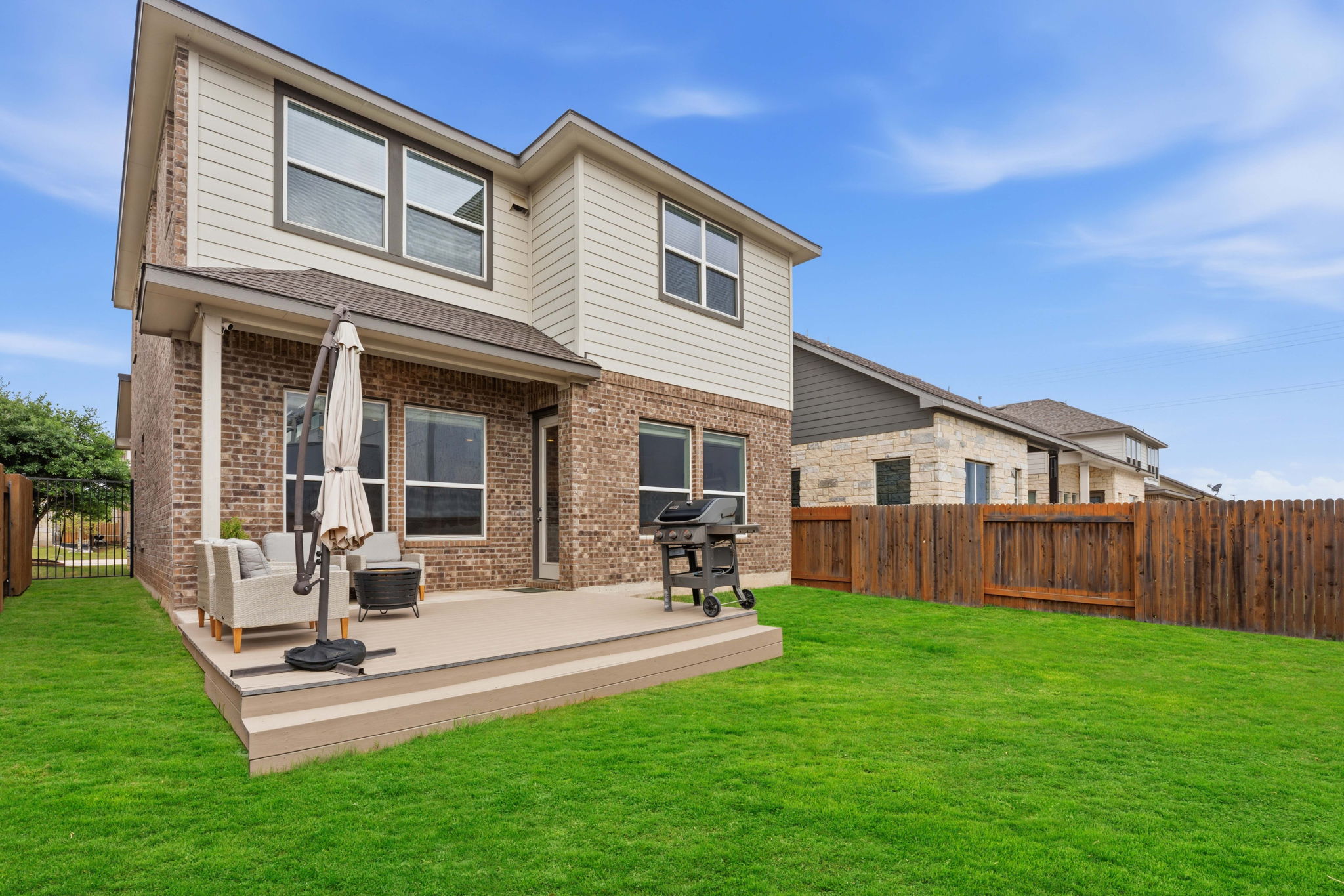 900 Old Mill Road, Unit 46 Cedar Park, TX 78613 - Photo 25 of 30 Rear view of property featuring a fenced backyard, brick siding, and a wooden deck