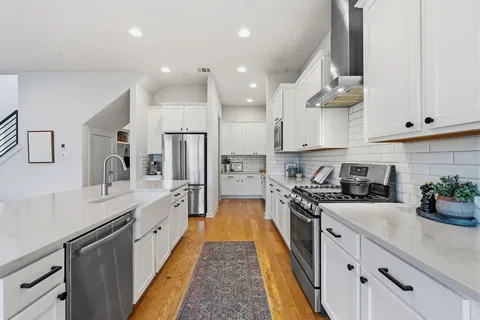 a kitchen with stainless steel appliances sink stove microwave and cabinets