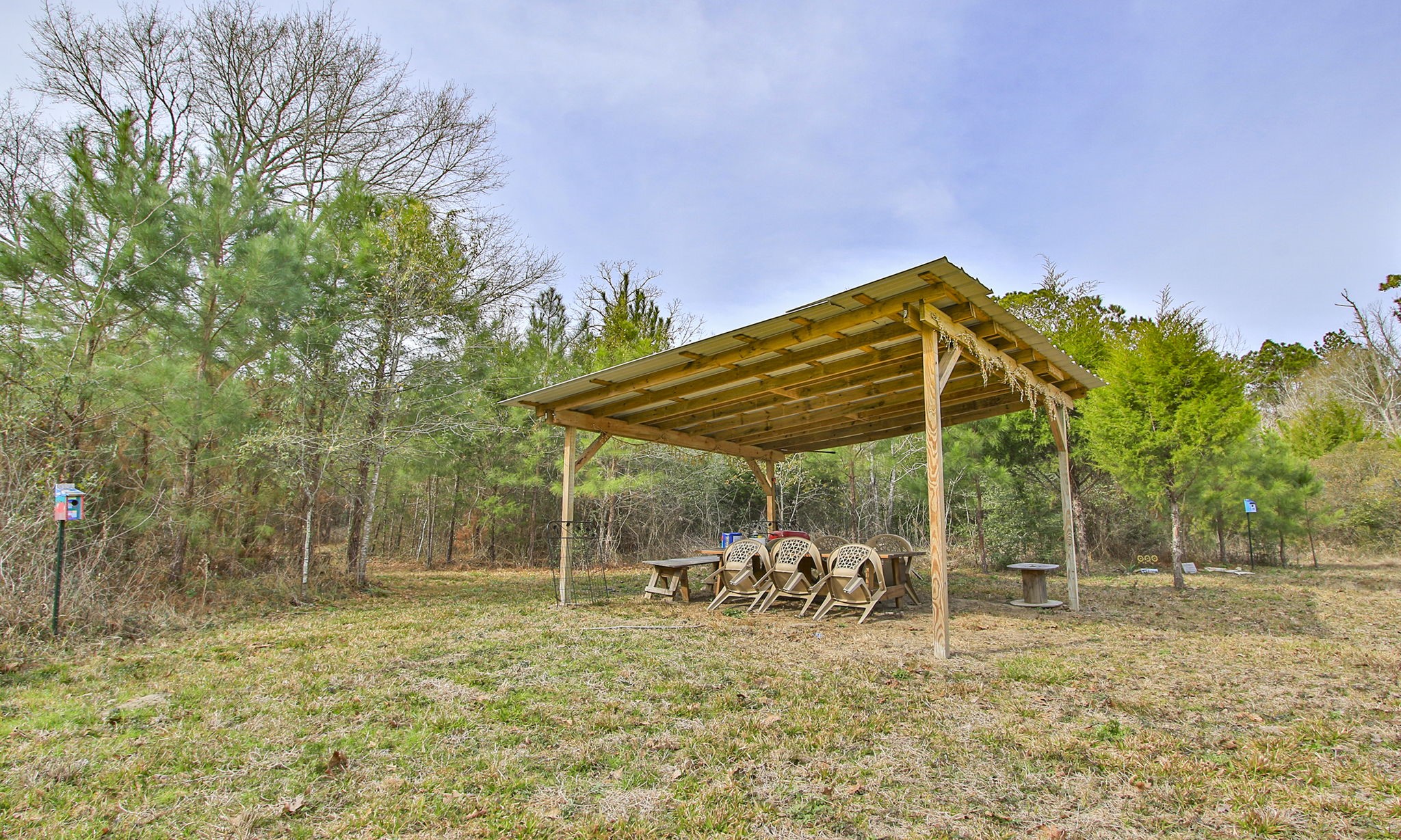 495 Pinecrest Drive Point Blank, TX 77364 - Photo 14 of 28 a view of a yard with table and chairs under an umbrella