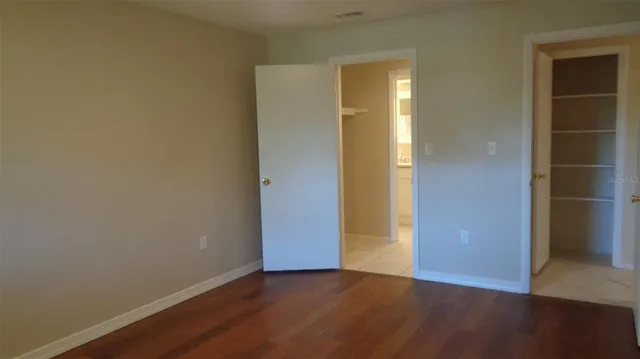 an empty room with wooden floor and closet