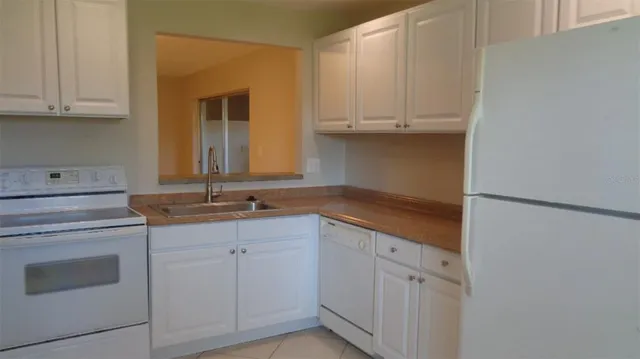 a kitchen with white cabinets and sink