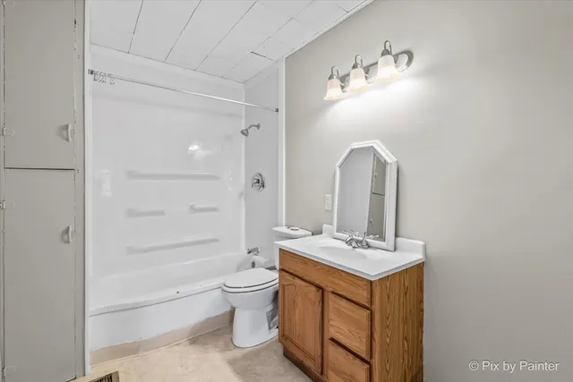 a bathroom with a double vanity sink a toilet and shower