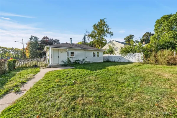 a view of a house with a big yard and potted plants