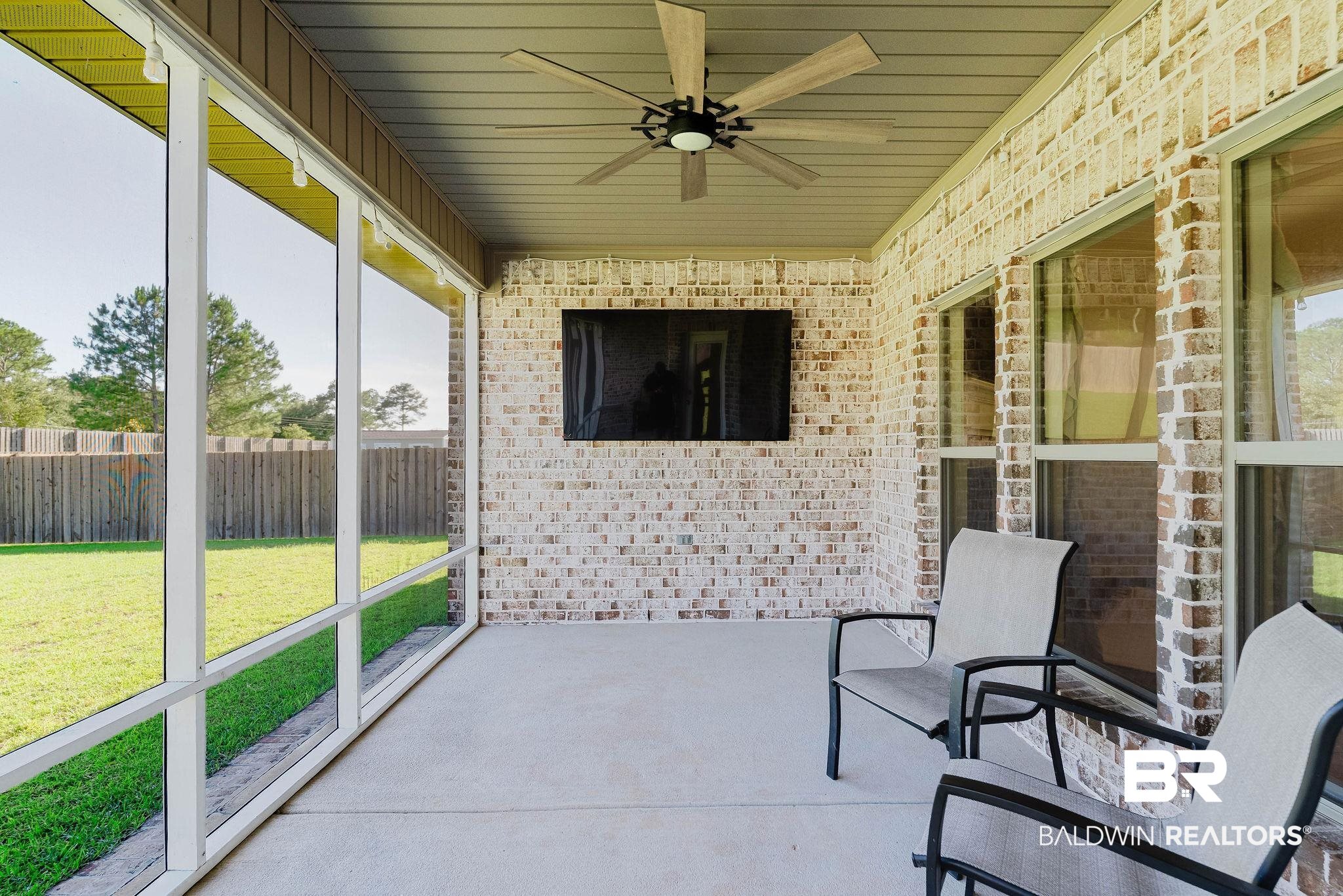 7872 Calverton Street Foley, AL 36535 - Photo 55 of 76 Screened patio featuring a ceiling fan, concrete flooring, brick exterior wall, and a built-in television mount