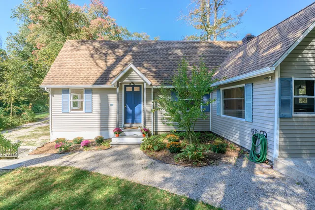 a front view of a house with a yard and potted plants