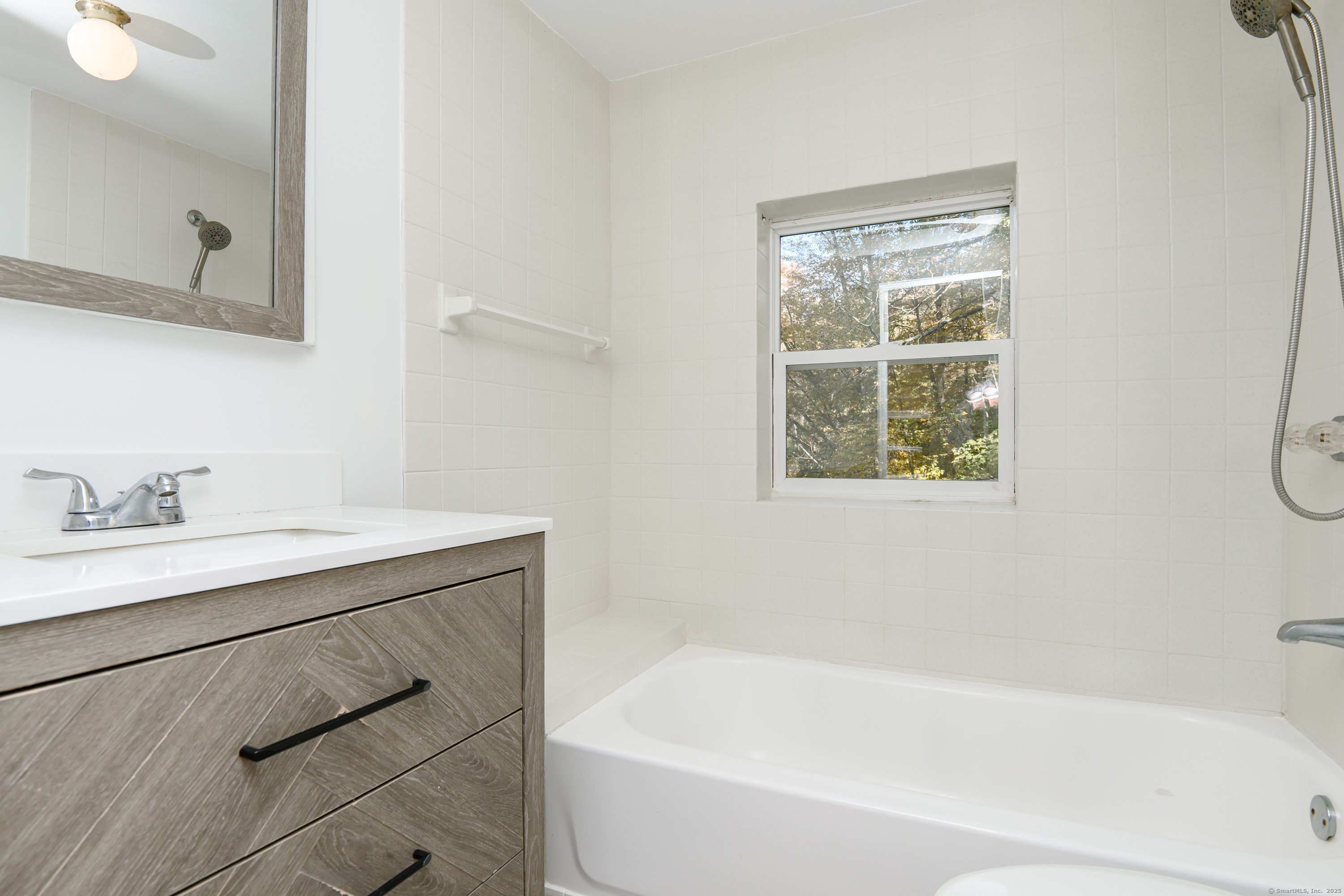 81 Picketts Ridge Road Redding, CT 06896 - Photo 12 of 28 a bathroom with a bathtub a sink a vanity and a window