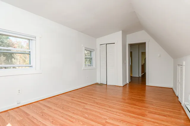 a view of an empty room with wooden floor