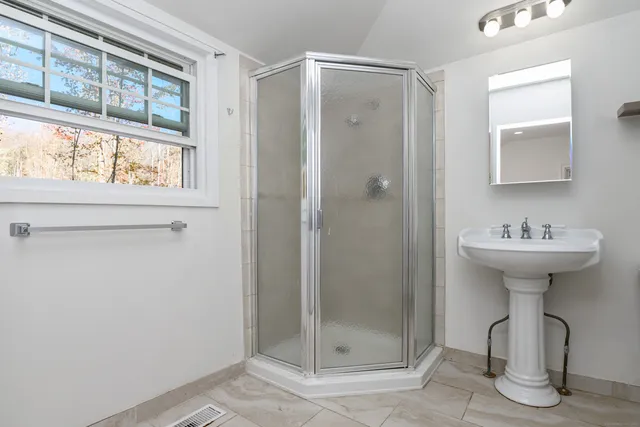 a bathroom with a shower sink and mirror