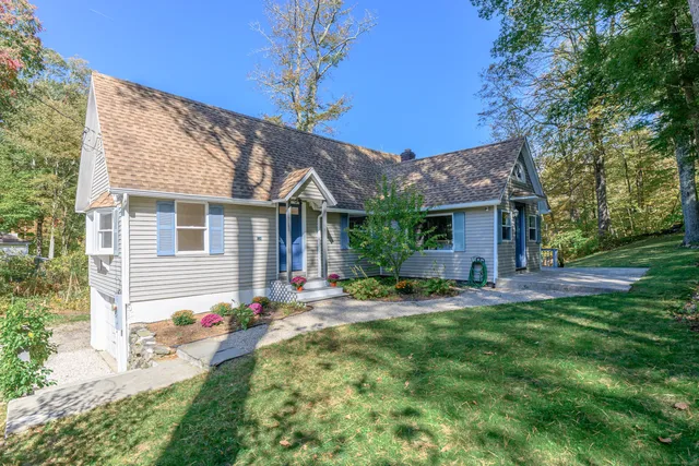 a backyard of a house with table and chairs and potted plants