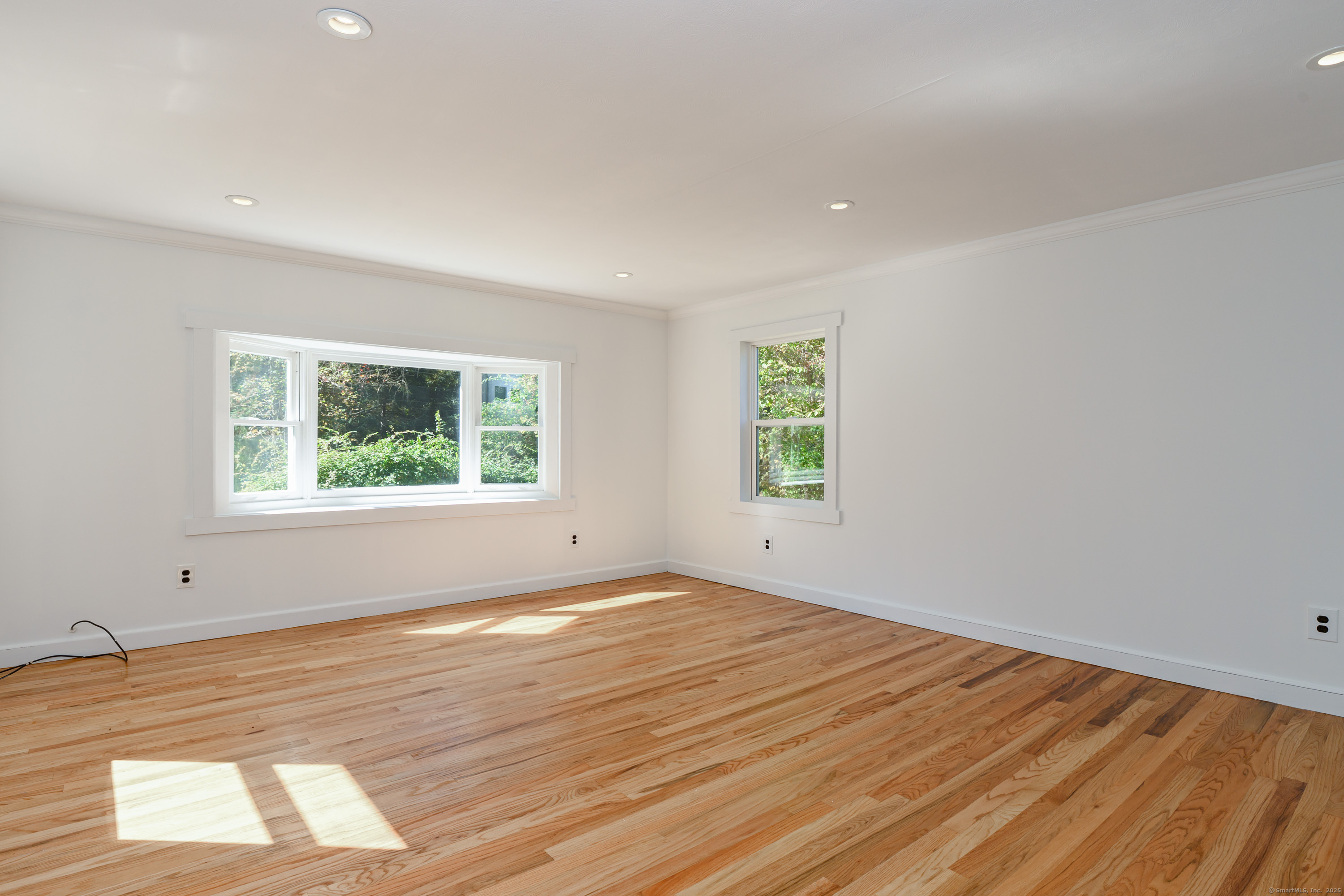 81 Picketts Ridge Road Redding, CT 06896 - Photo 9 of 28 an empty room with wooden floor and windows