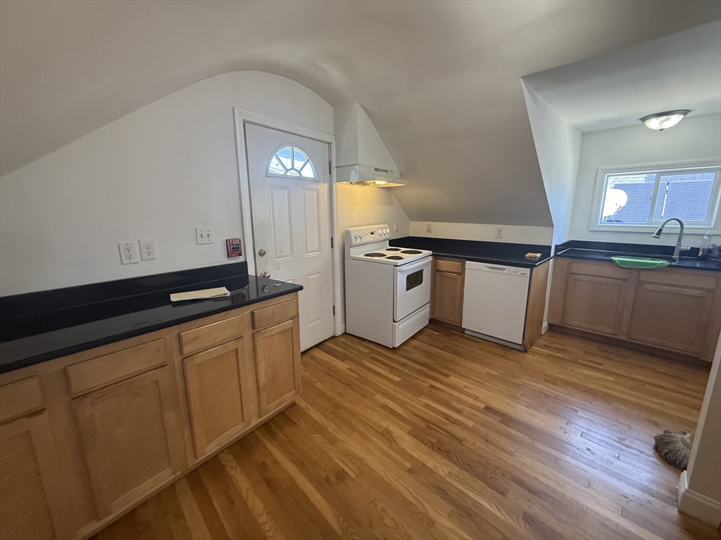 69 Beacon Street, Unit 3 Chelsea, MA 02150 - Photo 2 of 9 a kitchen with granite countertop a sink cabinets and stainless steel appliances